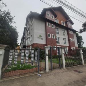 a building with a fence in front of it at Apartamento aconchego in Gramado
