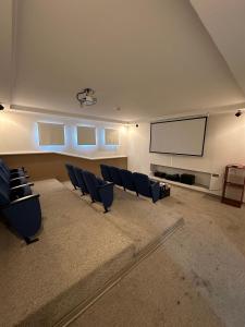 a large room with chairs and a projection screen at Departamentos Real in Santiago
