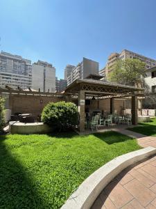 a gazebo with tables and chairs in a park at Departamentos Real in Santiago
