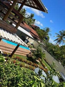 un resort con piscina, palme e piante di Casa amarela a Mata de Sao Joao