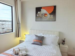 Uma cama ou camas num quarto em Orewa New house with view on deck near Cafe,bush & river