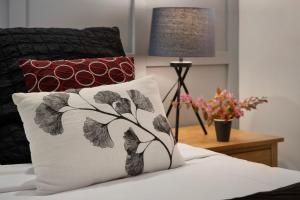 a pillow sitting on a bed next to a lamp at Villa Sorelle in the heart of Daylesford in Daylesford