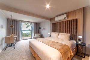 美洲河The River Suites, Kangaroo Island的有一张大床和一扇窗户的酒店房间