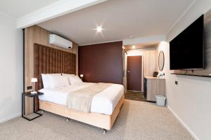 美洲河The River Suites, Kangaroo Island的一间配有一张大床和一台平板电视的卧室