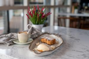 美洲河The River Suites, Kangaroo Island的一块蛋糕和一杯咖啡的盘子