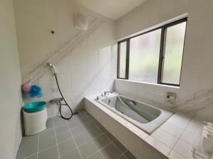 un bagno con vasca e finestra di Kamakura House a Kamakura Altre 55 foto