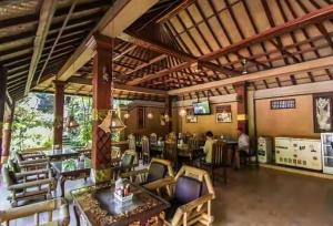 a restaurant with tables and chairs in a room at Dewa Bharata Bungalows Legian in Legian