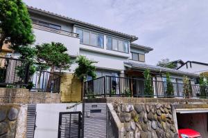 una casa con un muro di pietra e una recinzione di Kamakura House a Kamakura