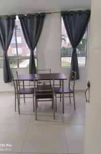 a table and chairs in a room with a window at El Indi0 Acostado in Villavicencio