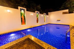 a swimming pool in a house at night at T Resort with Swimming Pool in Kottakupam