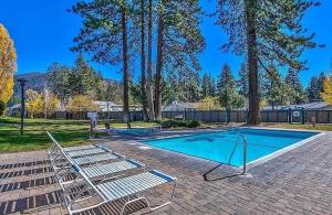 a swimming pool with two lounge chairs next to it at Bear Lake Hideaway condo in South Lake Tahoe
