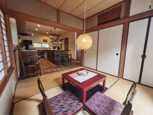 un soggiorno con tavolo e sedie e una cucina di Kamakura House a Kamakura