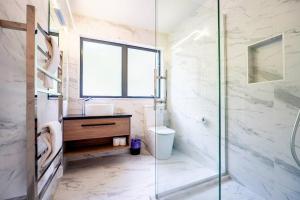 a bathroom with a glass shower and a sink at Family Friendly 4 Bedrooms House in Dairy Flat in Dairy Flat +38 photos