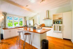 une cuisine avec des armoires blanches et un comptoir en bois dans l'établissement Horse Club Retreat 3 Bedrooms, à Dairy Flat