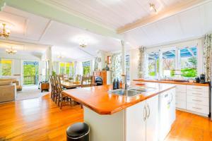 une cuisine et un salon avec une table et des chaises dans l'établissement Horse Club Retreat 3 Bedrooms, à Dairy Flat 29 autres photos