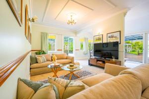 un salon avec des canapés et une télévision dans l'établissement Horse Club Retreat 3 Bedrooms, à Dairy Flat