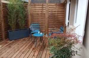 a patio with two chairs and a table on a deck at Love room Saphir- Balnéo & Sauna Privés in Oberbetschdorf