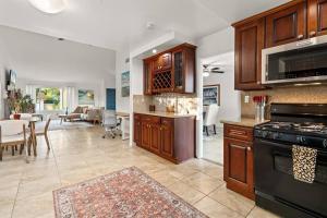 a kitchen with wooden cabinets and a living room at Luxury 4BD and 3BA in Topanga Oasis with Pool, Spa and Cabana in Glenview