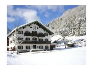 a large white building with snow on the ground at Thorau Alm Comfortable in Ruhpolding
