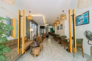 a living room with a couch and tables and chairs at Tò Vò Hostel Nguyễn Công Trứ in Hue