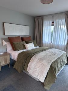 a bedroom with a large bed and a window at #1 Glenorchy Alpine DELUXE Suite in Glenorchy
