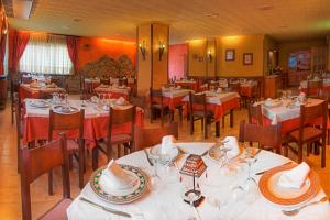 a dining room with tables and chairs with red table cloth at Hotel Casa Custodio in La Puebla de Roda