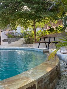 a picnic table next to a swimming pool at Palmhouse Boutique Hotel in Kuta Lombok