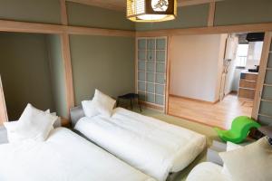 美瑛町青い池まで車で20分Biei Breeze Reserve的一间卧室设有两张床,墙上挂着一个时钟。