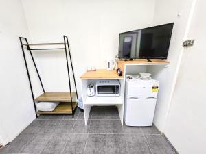 a small room with a tv and a microwave at Green Door Motel in Albury
