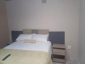 a bedroom with a large white bed and a night stand at Willow guest house in Vereeniging