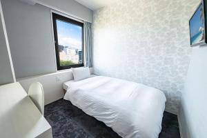 a small room with a bed and a window at Reisenkaku Hotel Kawabata in Fukuoka