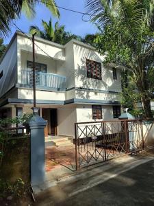a white house with a gate in front of it at Krishnarpanam 2BHK villa in Guruvayoor- only for families in Guruvāyūr