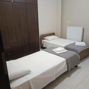 a bedroom with two beds and a cabinet at Drosoula house in Chania Town