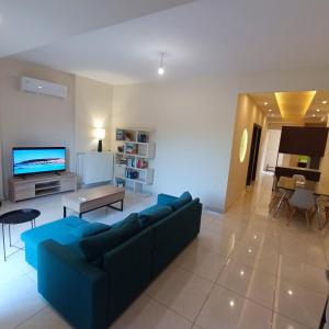a living room with a blue couch and a tv at Drosoula house in Chania Town