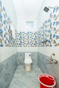 a bathroom with a toilet and a bucket in it at Hotel Balaji Rameswaram in Rāmeswaram