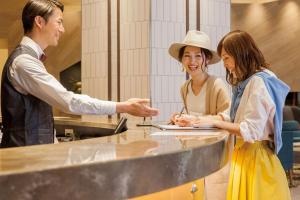 a man and two women standing around a counter at Comfort Suites Tokyo Bay in Urayasu