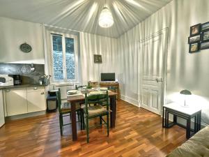 a living room with a table and a kitchen with a tableablish at Thermes et centre à pied, appartement calme, parking et wifi gratuit in Vals-les-Bains