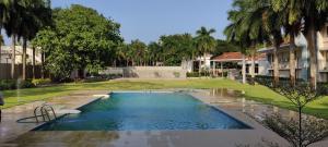 a swimming pool in a courtyard with palm trees at Hotel KPM Tripenta in Palakkad