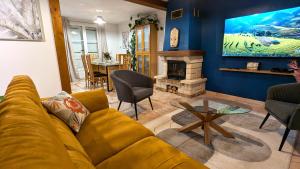a living room with a yellow couch and a fireplace at Les Marguerites in Bornel