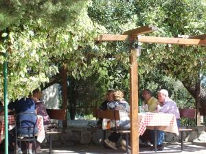 a group of people sitting at a table under an umbrella at Park Hotel Cilento in Marina di Camerota