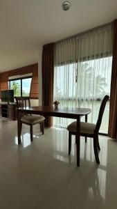 a dining room with a table and chairs and a couch at Apartment in Koh Samui