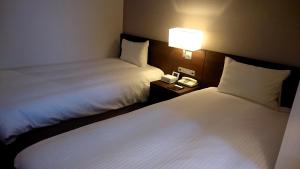 Postel nebo postele na pokoji v ubytování Chisun Hotel Kamata