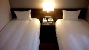 Postel nebo postele na pokoji v ubytování Chisun Hotel Kamata