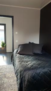 ein Schlafzimmer mit einem Bett mit einer schwarzen Bettdecke in der Unterkunft New Villa Paradise in Porvoo