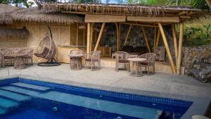 a pavilion with chairs and tables and a pool at Elang Hillside Bamboo Villas in Labuan Bajo