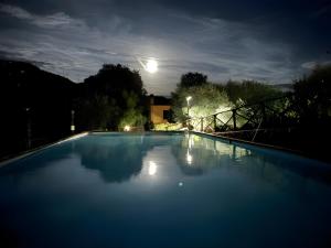 a large swimming pool at night with the moon at Ai Cinque Campanili in Finale Ligure