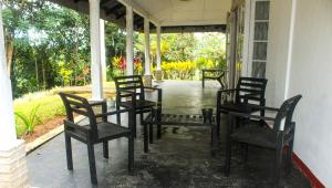 a group of chairs sitting on the porch of a house at HEYCOCK CEYLON HlLL in Gampola