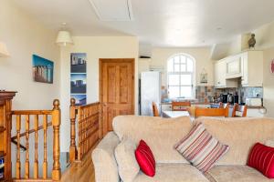 a living room with a couch and a kitchen at 10 Ballaghmore Cottages in Portballintrae