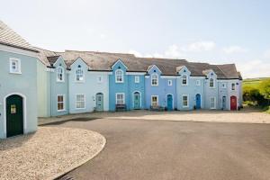 a row of blue buildings with a parking lot at 10 Ballaghmore Cottages in Portballintrae