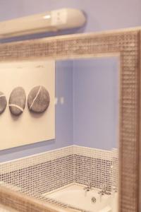 a mirror in a bathroom with a sink and two rocks at 10 Ballaghmore Cottages in Portballintrae +46 photos